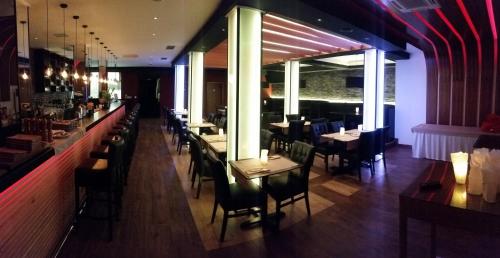 a restaurant with tables and chairs and a bar at Sunset Split Rooms in Podstrana