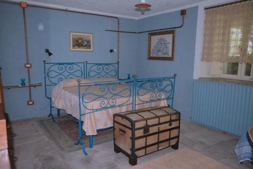 a blue bedroom with a bed and a stool at Palazzo Jannoni Holiday in SantʼAndrea Apostolo dello Ionio