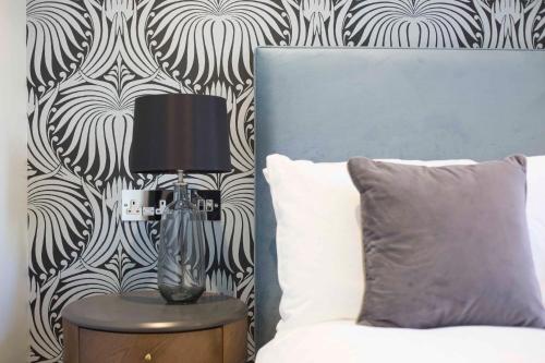 a lamp sitting on a table next to a bed at No.8 Waterloo Street in Birmingham