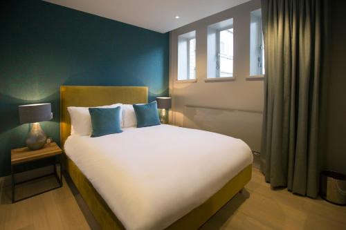 a bedroom with a large white bed with blue walls at No.8 Waterloo Street in Birmingham