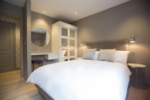 a bedroom with a large white bed and a television at No.8 Waterloo Street in Birmingham