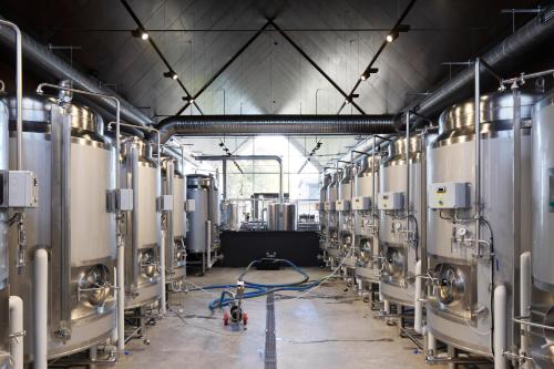 a brewery with a row of silver tanks at Zoltners Hotel in Tērvete