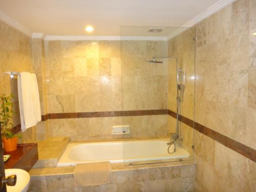 a bathroom with a bath tub and a sink at Private Apartments at Jayakarta Resort in Legian