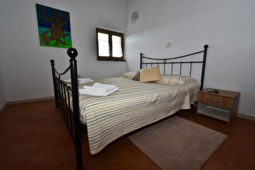 a bedroom with a black bed with a striped blanket at Rooms Agroturizam Romano in Buje