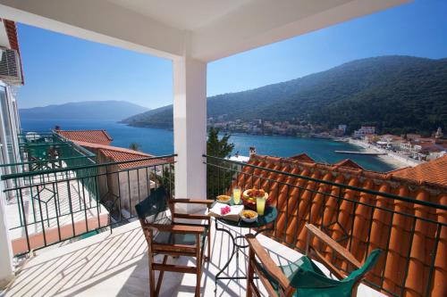 a balcony with a table and chairs and a view of the water at Boulevard Aetos Suites in Ayia Evfimia