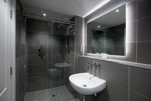 a bathroom with a sink and a shower with a mirror at No.8 Waterloo Street in Birmingham