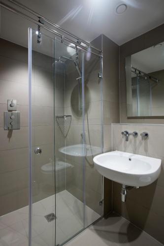 a bathroom with a sink and a glass shower at No.8 Waterloo Street in Birmingham