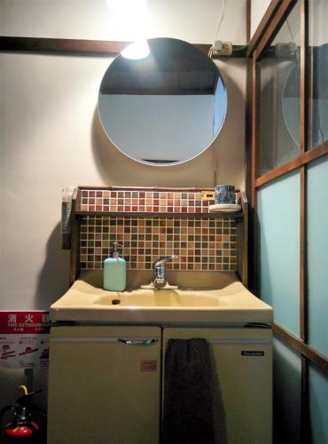 a bathroom with a sink and a mirror at Murasakino Guesthouse in Kyoto