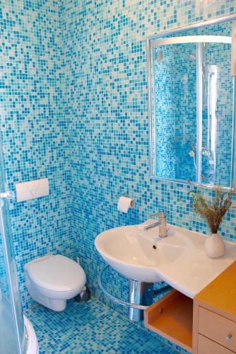 a blue tiled bathroom with a sink and a toilet at Villa St Roko - Charme Holidays in Sutivan