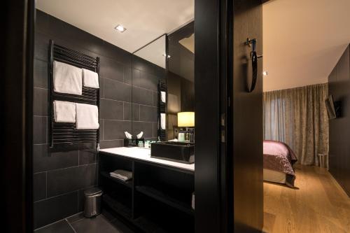a bathroom with a sink and a mirror at La Mansion Vi Vadi Hotel in Munich