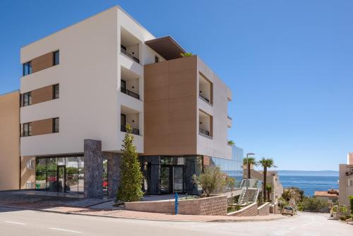 a white building with the ocean in the background at Boutique Hotel Ani - Adults Only in Makarska