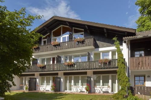 ein Apartmenthaus mit Balkonen und Fenstern in der Unterkunft HYPERION Hotel Garmisch - Partenkirchen in Garmisch-Partenkirchen