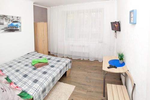リヴィウにあるApartment on Lychakivska 161のベッドルーム1室(ベッド1台、テーブル、窓付)