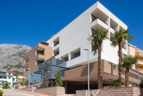 a building with palm trees in front of it at Boutique Hotel Ani - Adults Only in Makarska