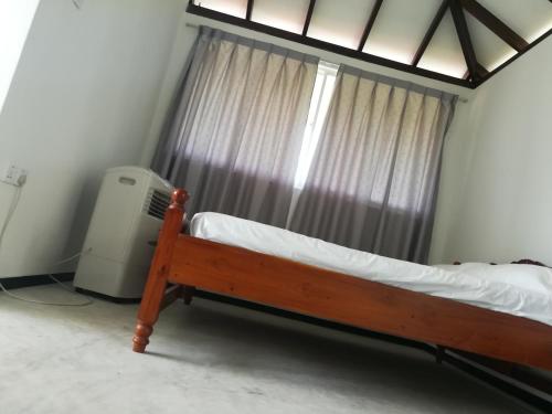 ein Bett in einem Zimmer mit Fenster und Heizkörper in der Unterkunft Ceylon Ramble Villa in Hikkaduwa