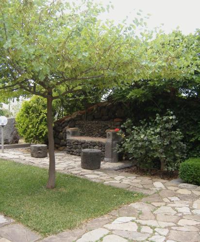 a stone wall with a bench under a tree at La Tavernetta in Randazzo