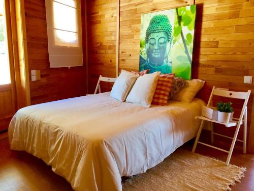 una camera da letto con un letto e un dipinto sul muro di Casita de madera a Benicarló