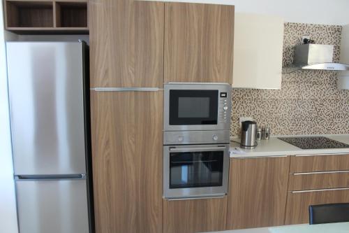 a kitchen with a refrigerator and a microwave at Panorama Mediterranea in St Paul's Bay
