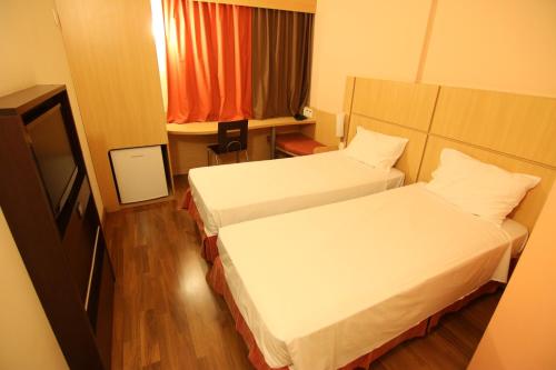 a hotel room with two beds and a window at Samba Itaboraí in Itaboraí