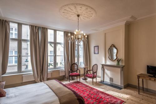 a bedroom with a bed and a chandelier at Braamberg B&B in Bruges