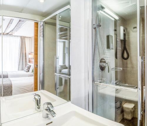 uma casa de banho com um lavatório e um chuveiro em Hotel Chabrol Opera em Paris