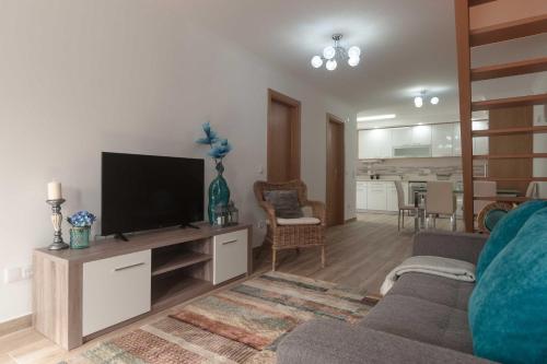 a living room with a flat screen tv on a entertainment center at WestSide Beach House in Peniche