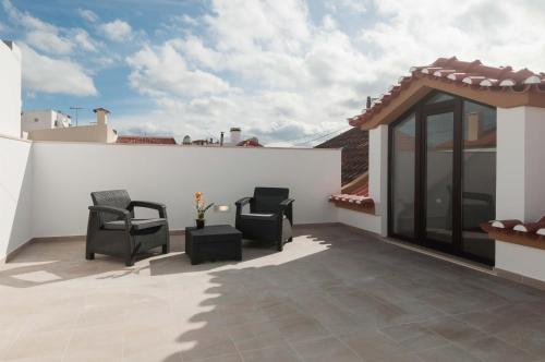 a patio with two chairs and a table at WestSide Beach House in Peniche