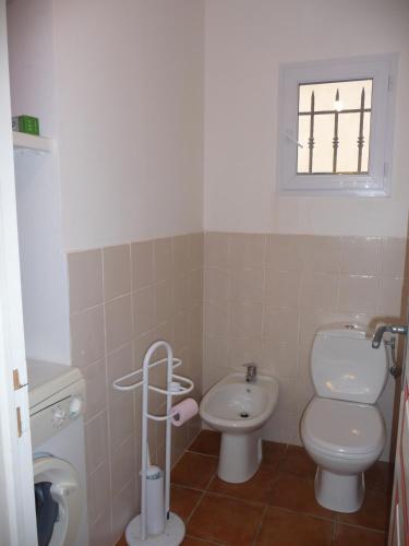 une petite salle de bain avec toilettes et lavabo dans l'établissement Villa Les Hameaux Di Santa Giulia, à Porto-Vecchio