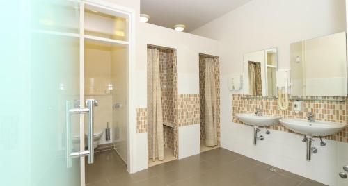 a bathroom with two sinks and two mirrors at Hotel Indijan in Orebić