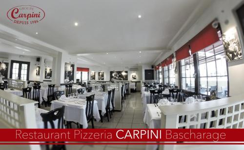 um restaurante com mesas brancas e cadeiras pretas em Hotel Carpini em Bascharage