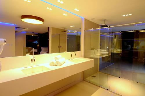 a bathroom with two sinks and a large mirror at Le Ville in Ouro Preto
