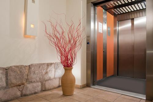 a vase with a red plant in a hallway at Hotel Vivaldi in Karpacz