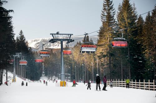 a group of people skiing on a ski lift at Hotel Vivaldi in Karpacz