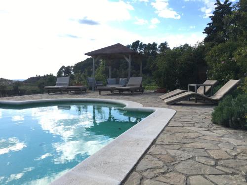 una piscina con bancos y un cenador en Celler Colltor, en Santa María de Oló