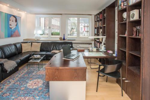 a living room with a couch and a table with a laptop at Apartement mit Dachterrasse - bei Curth klingen - Teilen Sie uns Ihre Ankunfszeit mit in Düsseldorf