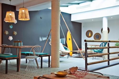 a room with chairs and a table and swings at The Salty Lodge in Lagos