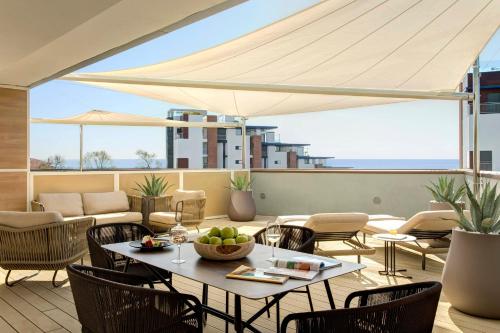 a patio with a table with a bowl of fruit on it at Almar Jesolo Resort & Spa in Lido di Jesolo