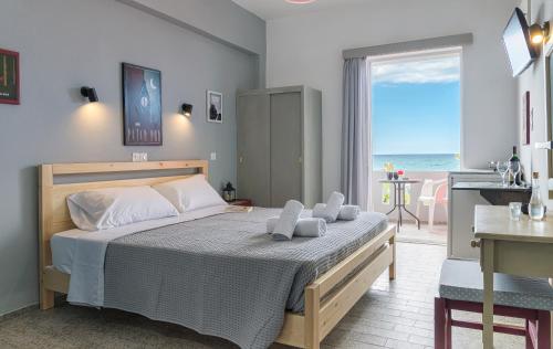 a bedroom with a bed with a view of the ocean at Star Apartments in Rethymno Town