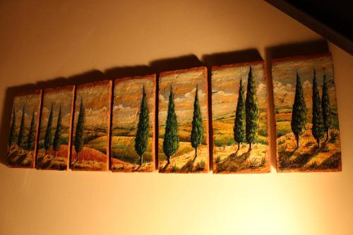 a painting of trees is hanging on a wall at Antico Borgo Casalappi in Campiglia Marittima