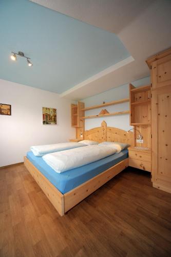 a bedroom with a large bed and wooden cabinets at Oberpiskoihof in Funes