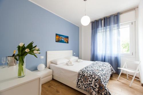 a bedroom with a white bed and a vase of flowers at Bongiorno Home Private Free Parking Venice 10' in Marghera