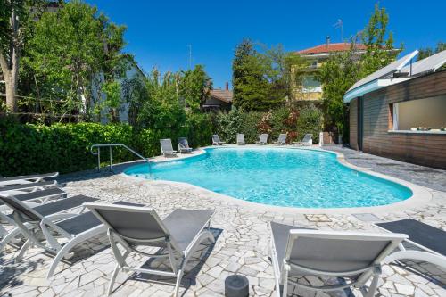 a swimming pool with chairs and a swimming pool at Hotel Buona fortuna in Bellaria-Igea Marina