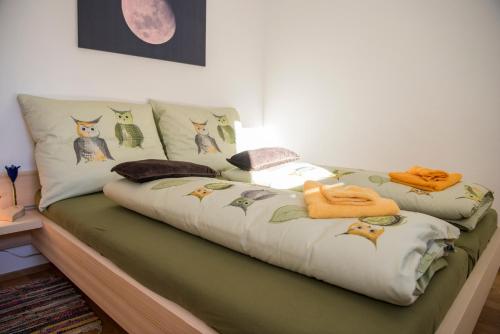 Una cama con almohadas de gatos encima. en Ferienwohnung Fionas 267 en Ftan