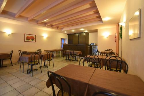 une salle à manger avec des tables et des chaises ainsi qu'une cuisine dans l'établissement Logis Hôtel Saint Jacques, à Valence