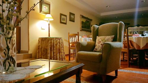 a living room with a chair and a coffee table at Hotel La Rivera in Arenas de Cabrales