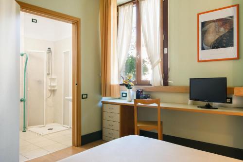 una camera da letto con scrivania, computer e finestra di Duca Del Mare - Hotel Di Nardo group a Massa Marittima