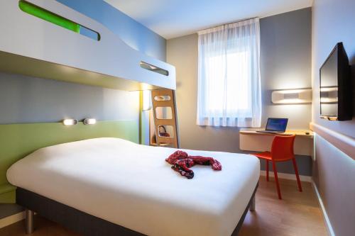 a bedroom with a bed with a teddy bear on it at Ibis Budget Limoges Nord in Limoges