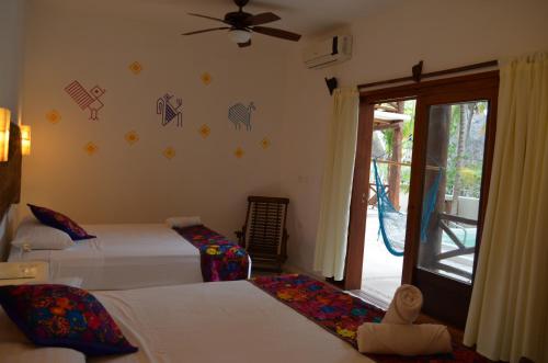 A bed or beds in a room at Casa Iguana Holbox - Beachfront Hotel