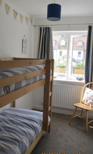 a bedroom with two bunk beds and a window at Chloe Cottage in Whitstable