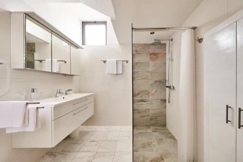 a white bathroom with a shower and a sink at Apartment Sandro in Vilanija
